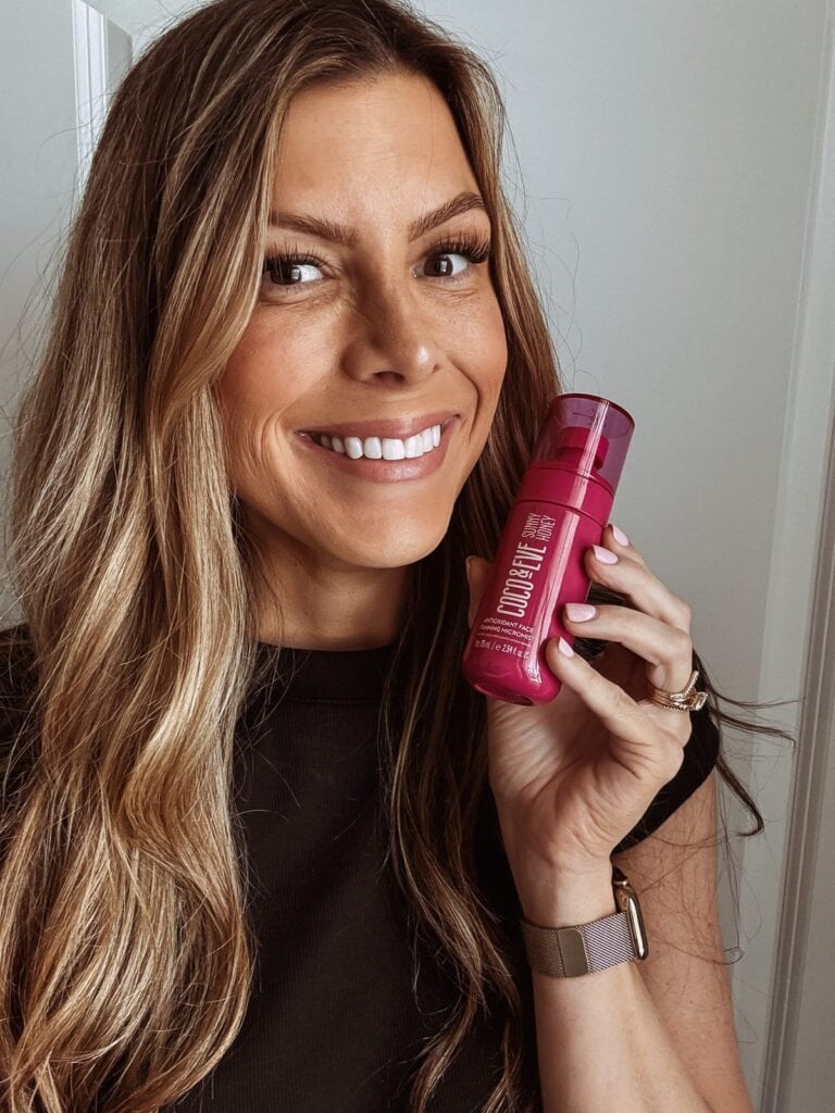 Corrine holding a bottle of Coco & Eve Self Tanning Mist