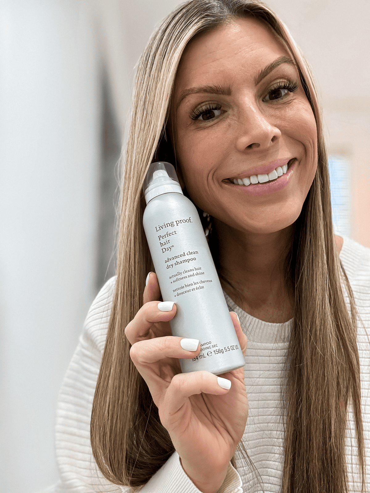 Corrine holding Living Proof Hairspray
