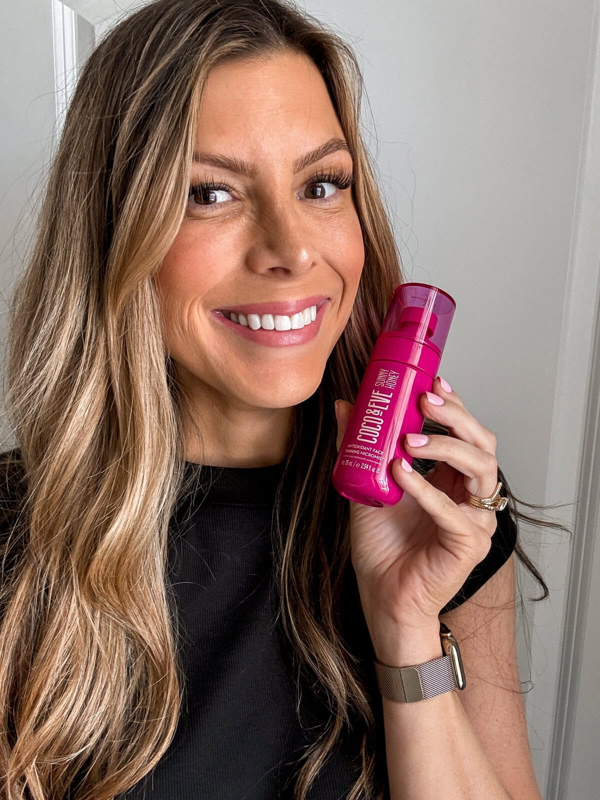 Corrine holding the Coco & Eve Antioxidant Face Tanning Micromist