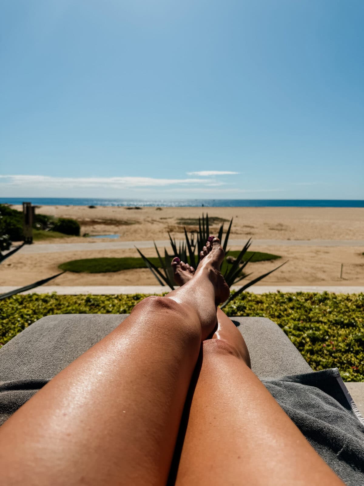 Sun-kissed legs at the beach with Coco & Eve Tan Boosting SPF 20 Body Oil