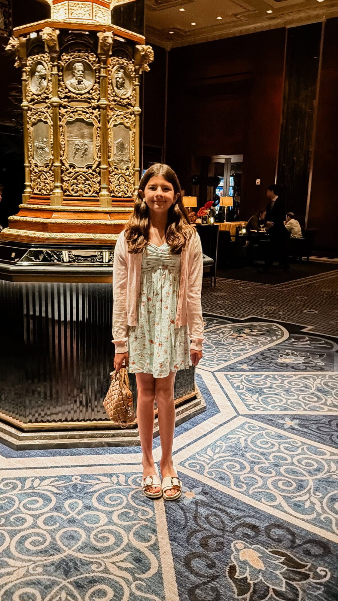 Tween daughter dressed up in a blue floral sundress in the Waldorf Astoria hotel lobby in NYC