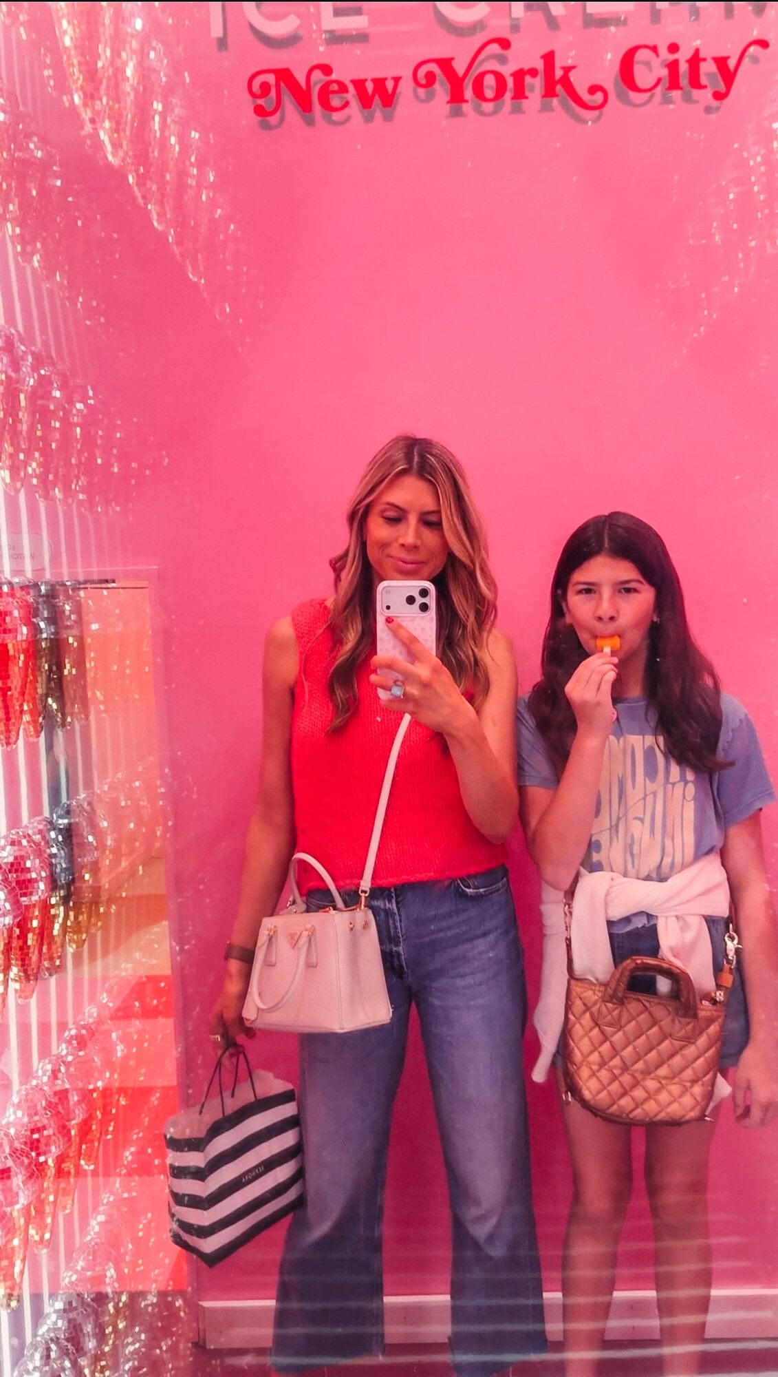 Mom and tween posing in front of a pink Museum of Ice Cream NYC sign