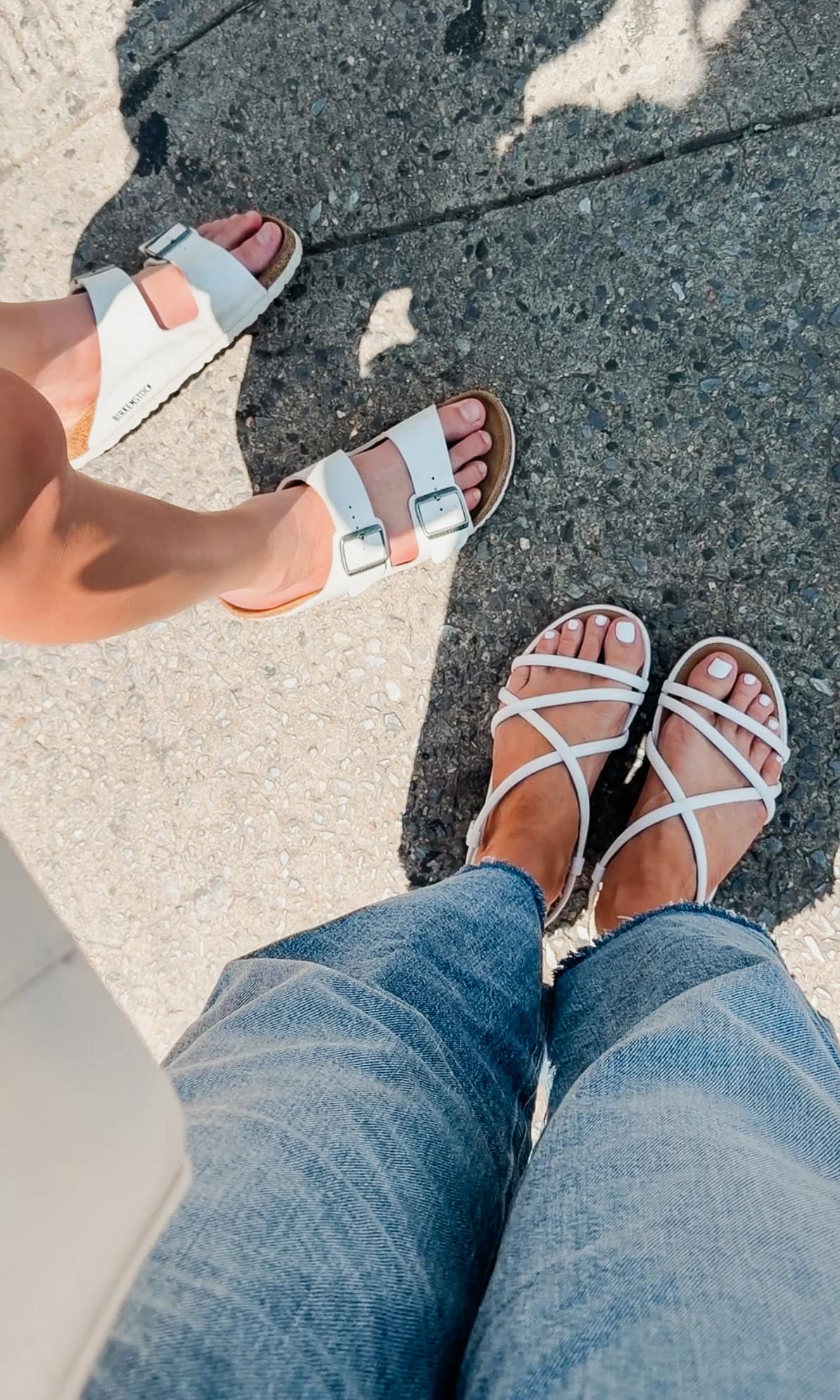 White Birkenstock sandals and white FitFlop Gracie strappy sandals side by side on a NYC street