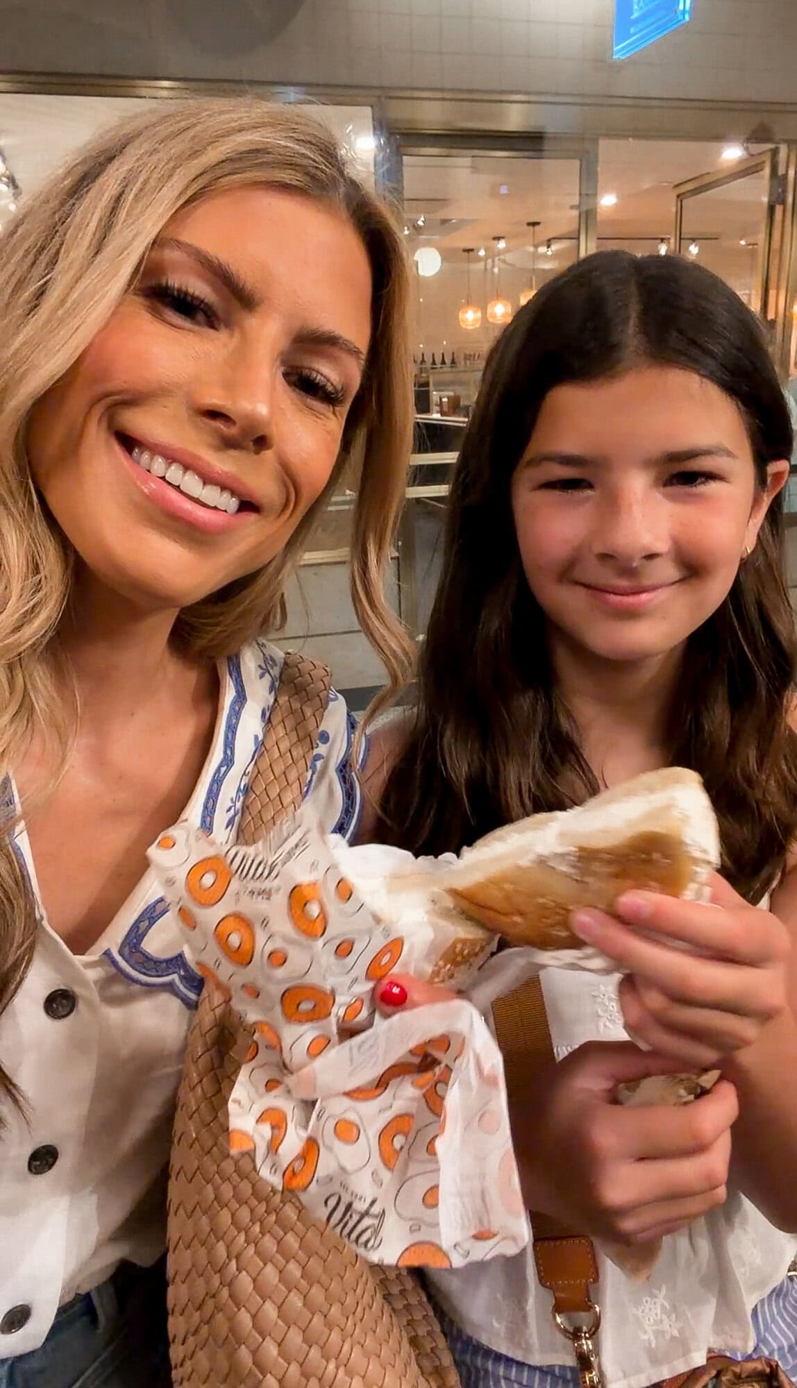 Mom and tween daughter eating Black Seed bagels for breakfast at Rockefeller Center in New York City