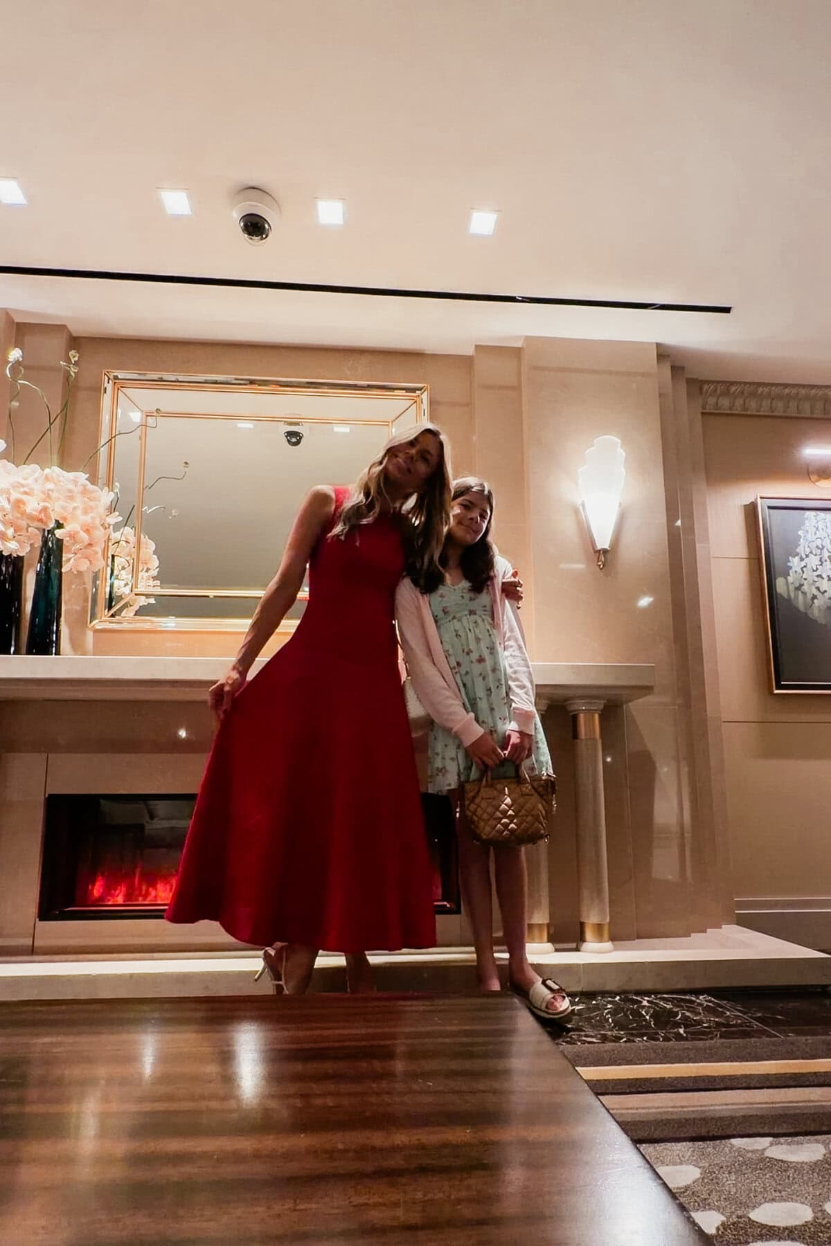Corrine in red dress with daughter in hotel lobby