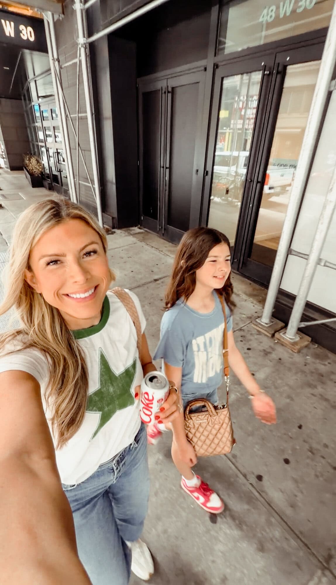 Corrine wearing the Letluv white and green star ringer tee walking in Manhattan with her daughter