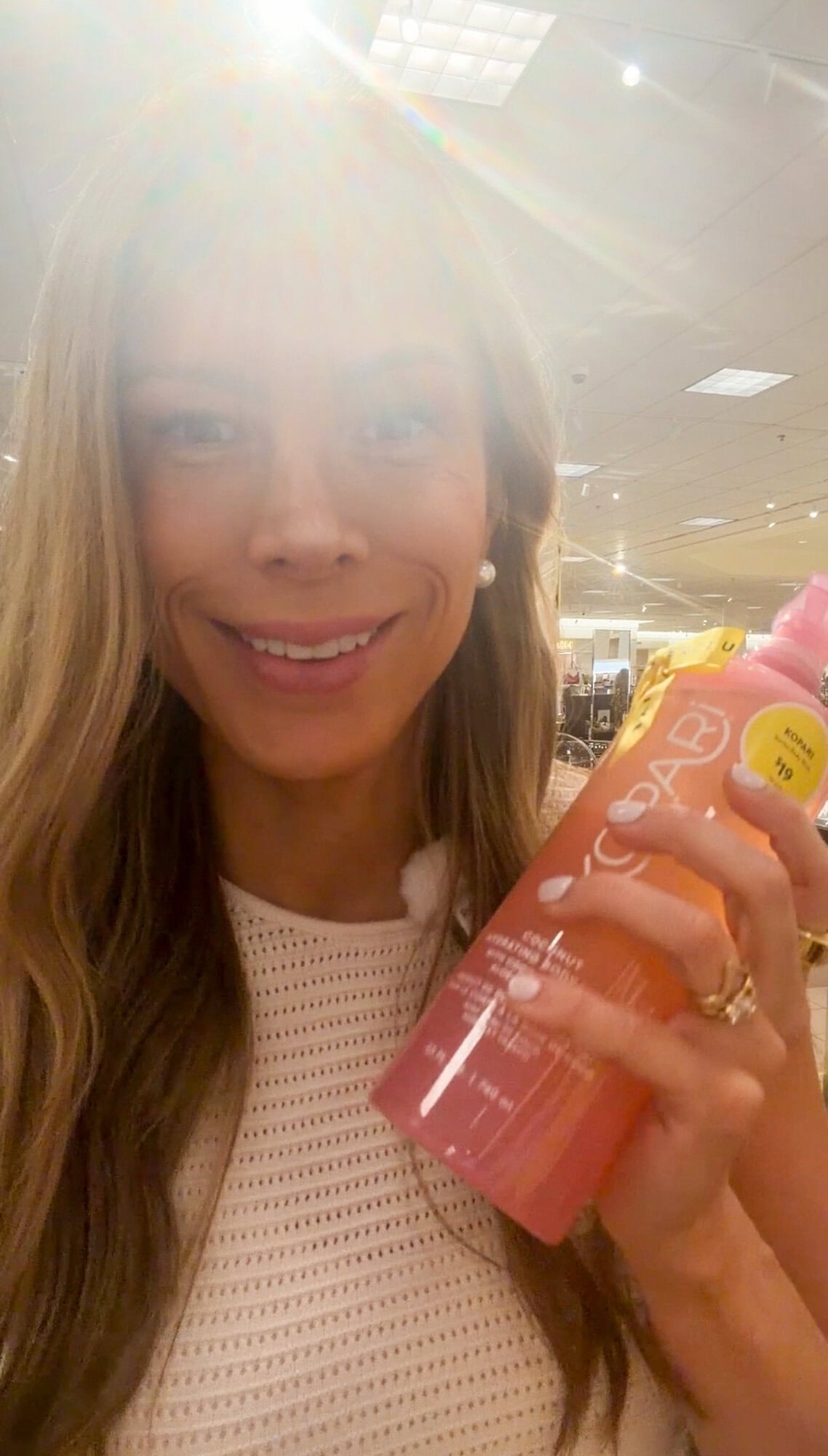 Corrine holding the Kopari coconut body wash mega size at Nordstrom