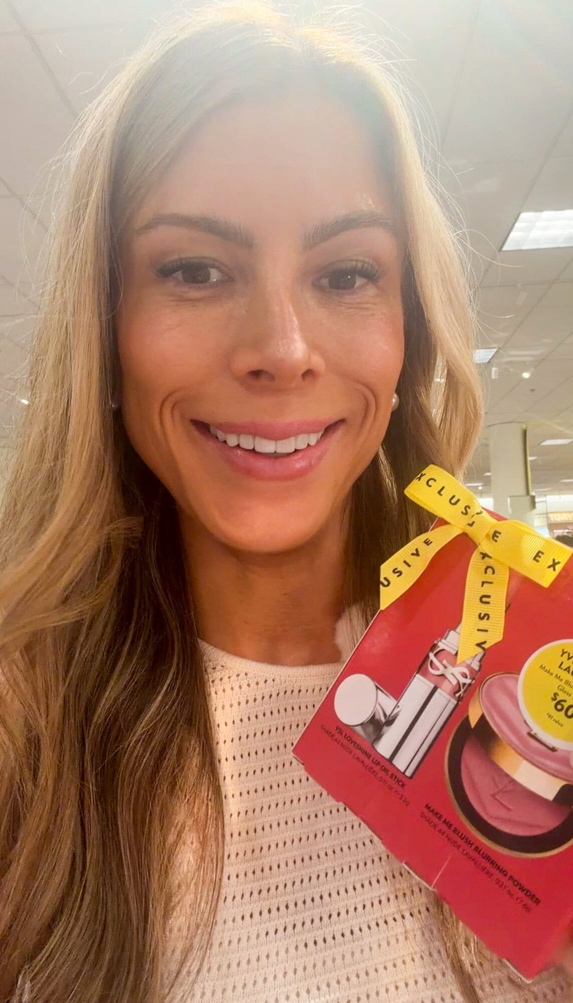 Corrine holding the YSL Make Me Blush and Loveshine lip oil stick set at Nordstrom
