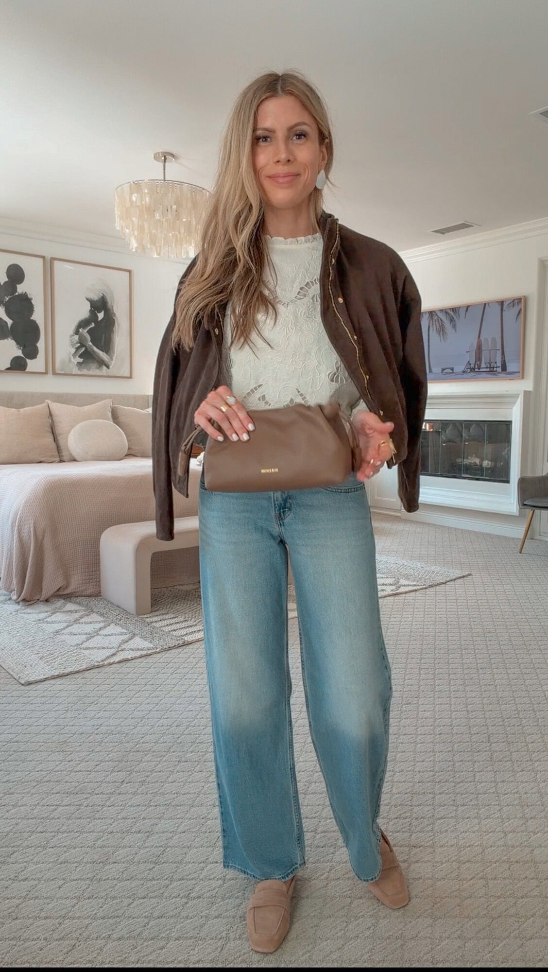 Corrine in a brown suede jacket over a floral cutwork linen blouse and low-rise jeans