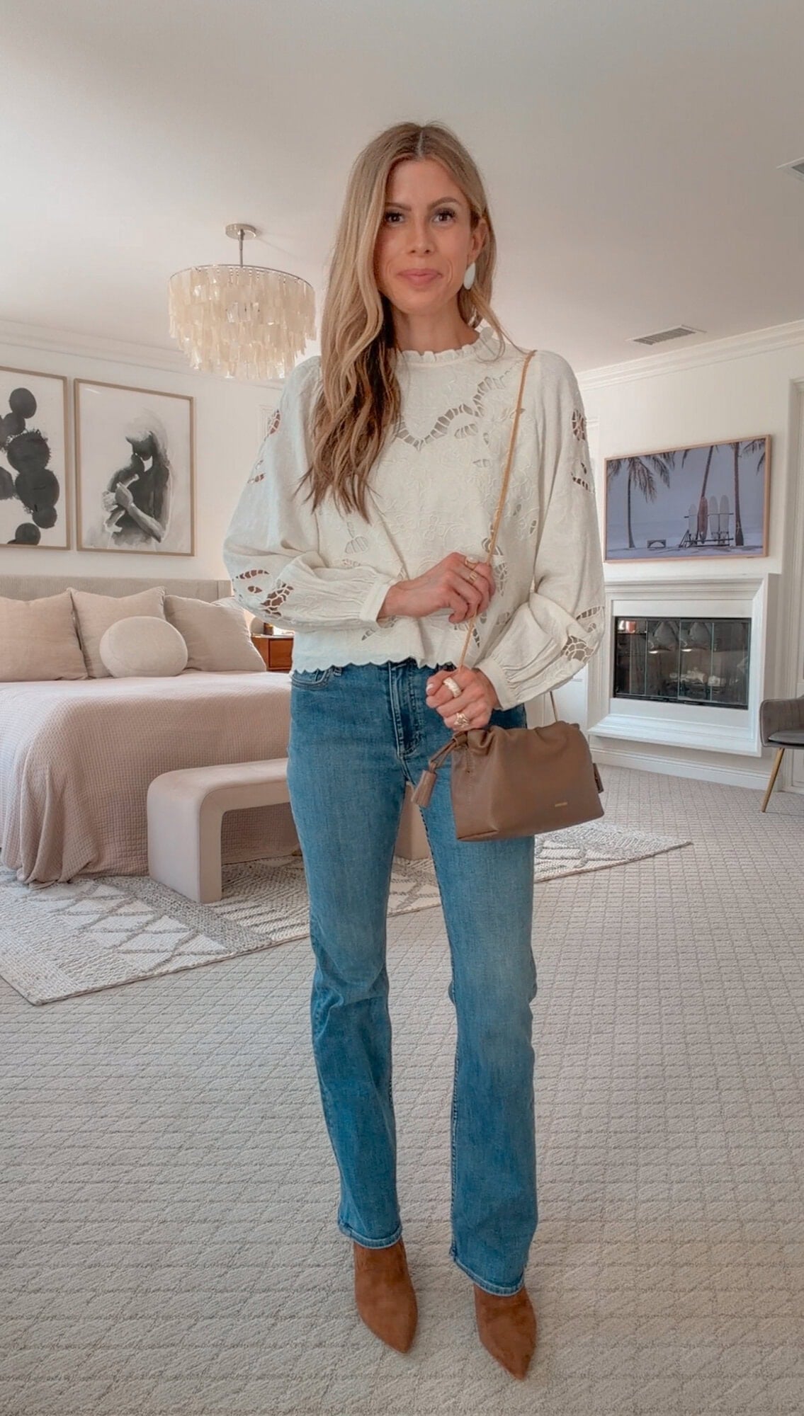 Corrine in a floral linen blouse, bootcut jeans, and heeled booties