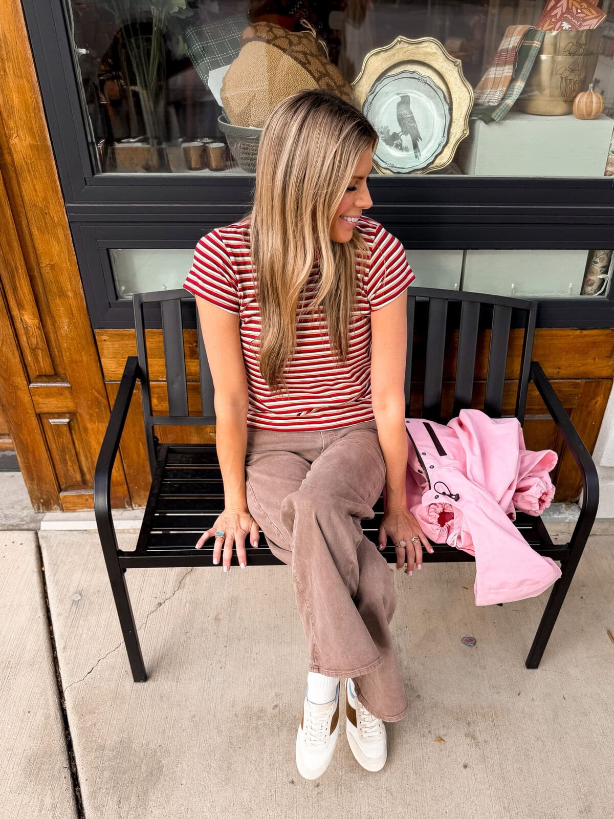 Low profile runner sneakers worn with brown wide leg jeans and a striped tee